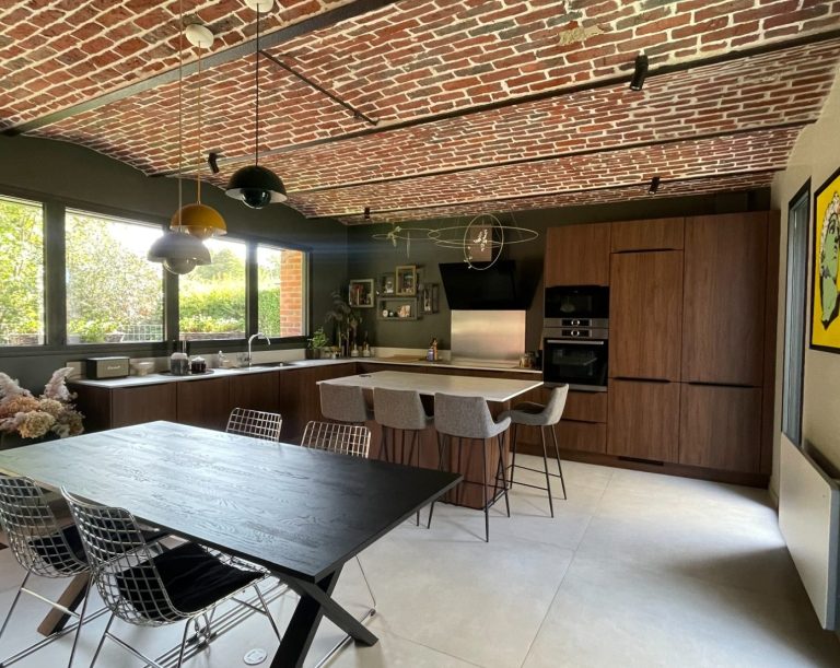 Salle à manger moderne avec une grande table noire et des chaises vertes, décorée de fleurs.